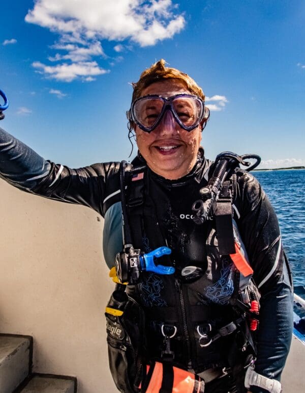 A person in scuba gear on the side of a boat.