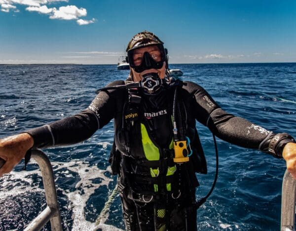 A scuba diver in the water with his arms out.