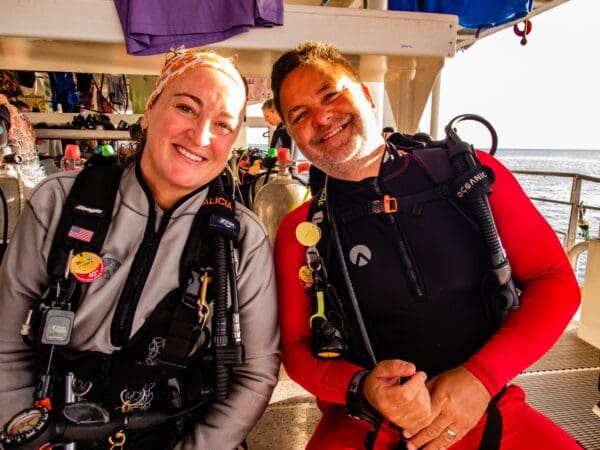 Two people in scuba gear smiling for a picture.