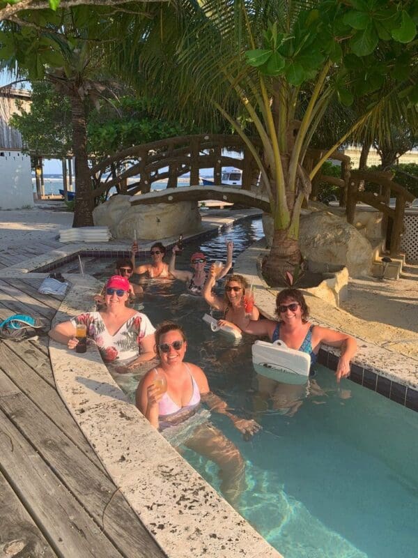 A group of people sitting in the water at a resort.