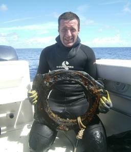 A man in black wetsuit holding a life ring.