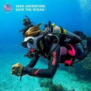 A scuba diver is holding something in his hand.