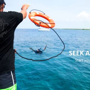 A man holding onto a rope while standing in the water.