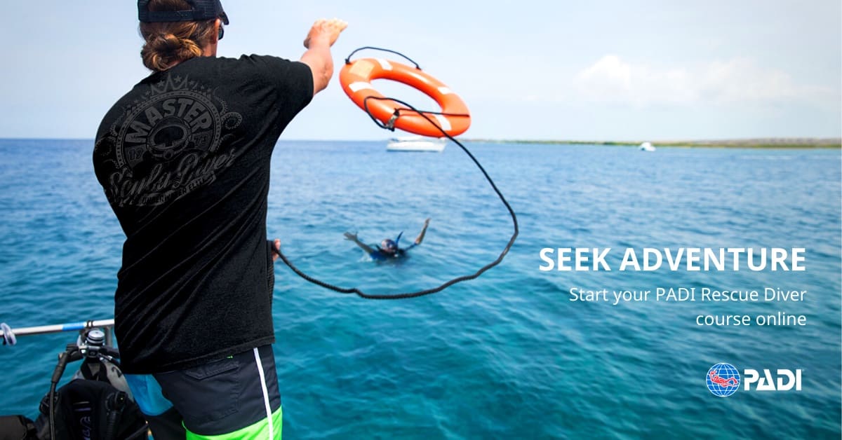 A man holding onto a rope while standing in the water.