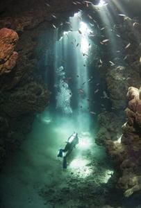 A person in the water near some rocks