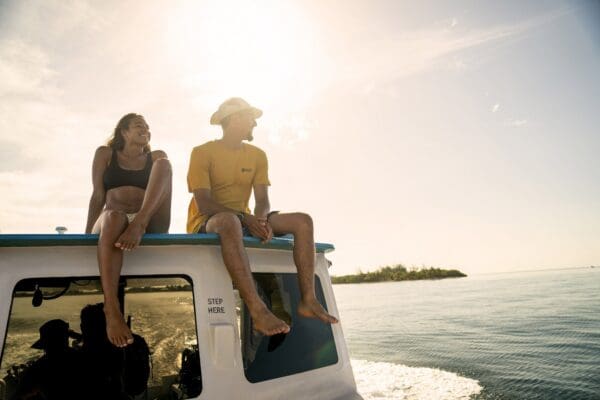 A man and woman sitting on the back of a boat.