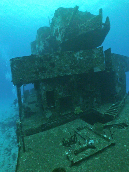 A boat is sitting in the ocean under water.