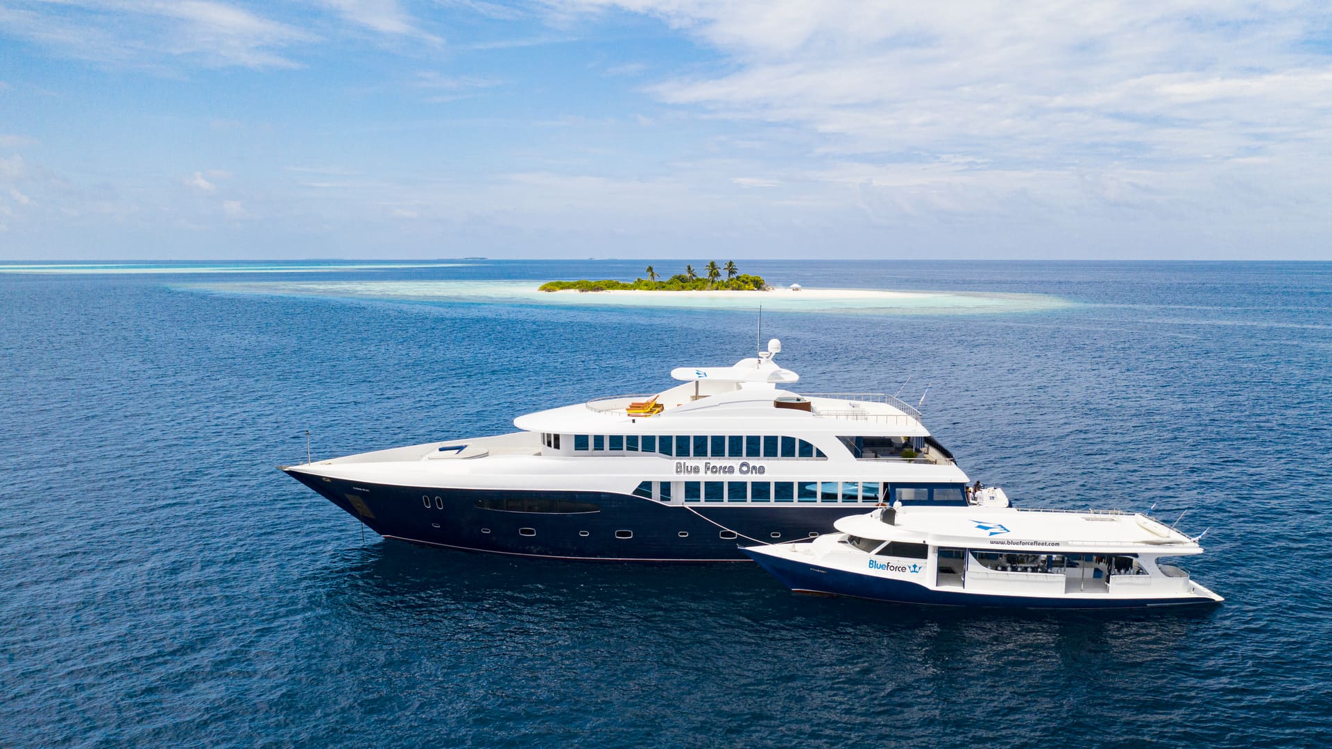 A large white boat in the ocean next to another boat.