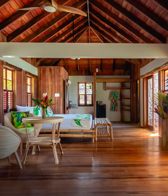 Tropical bungalow with wooden furniture and a bed.