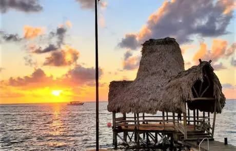 Sunrise over thatched hut on the beach.