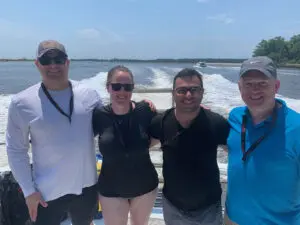 Four people on a boat smiling.