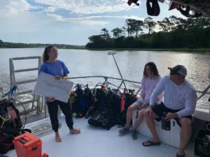 Woman holding a diving map on a boat.