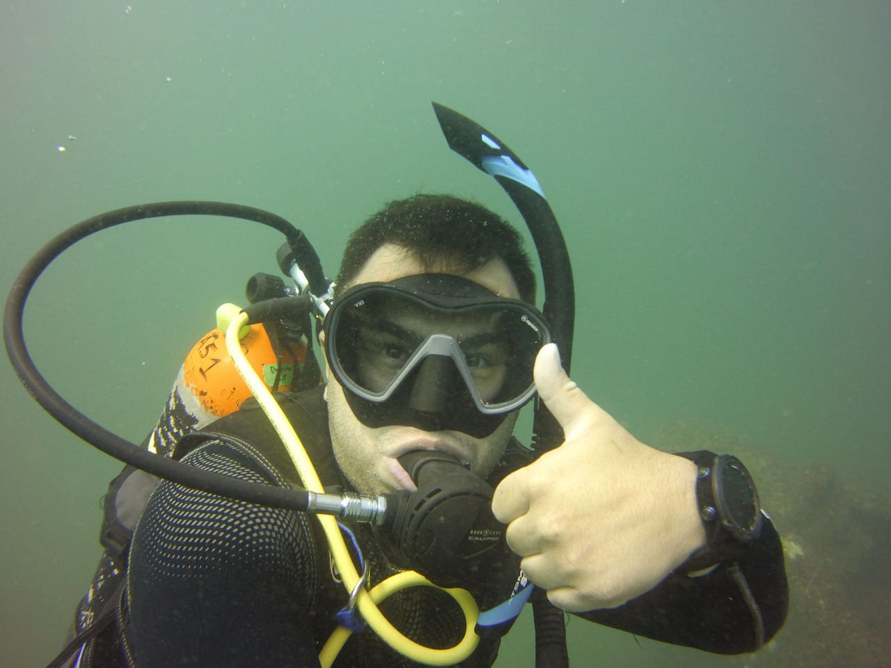 Scuba diver giving thumbs up underwater.