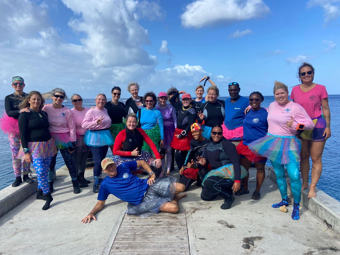 Group of divers in tutus on a dock.