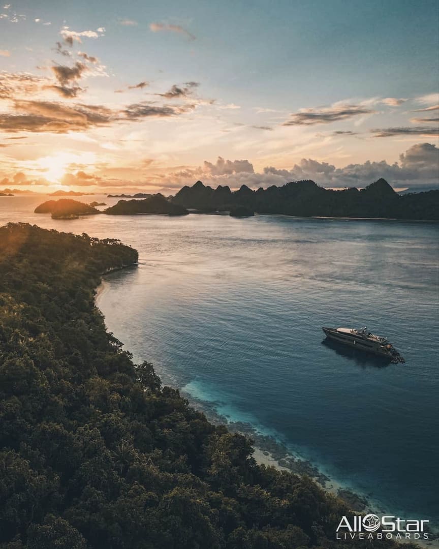 Boat on blue water with lush islands.