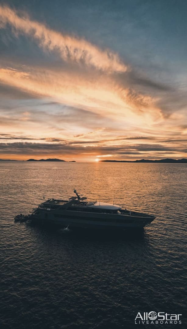 A yacht at sunset on the ocean.