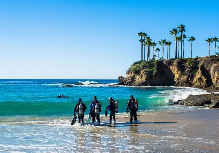 A group of people standing on top of a beach.