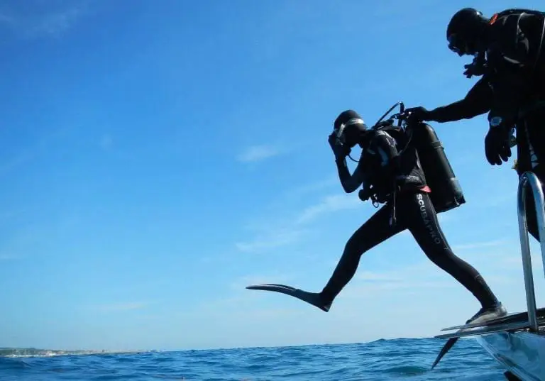 Scuba divers entering the ocean.